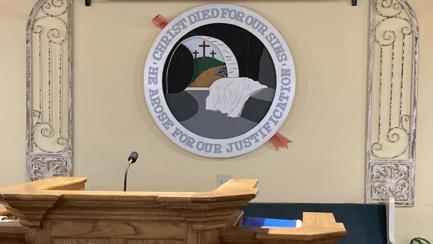 The pulpit at East Side Baptist Church, with the church seal on the wall behind it